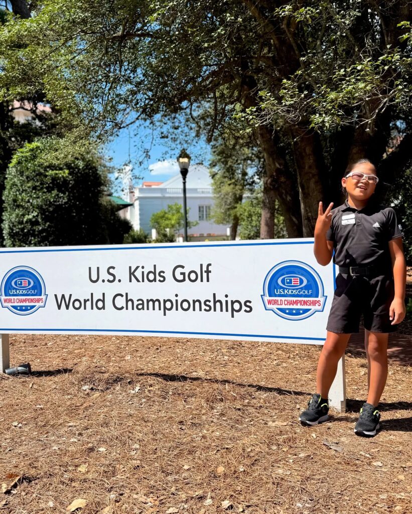 U.S. Kids Golf World Championshipsの看板前に立つ荒砂士道