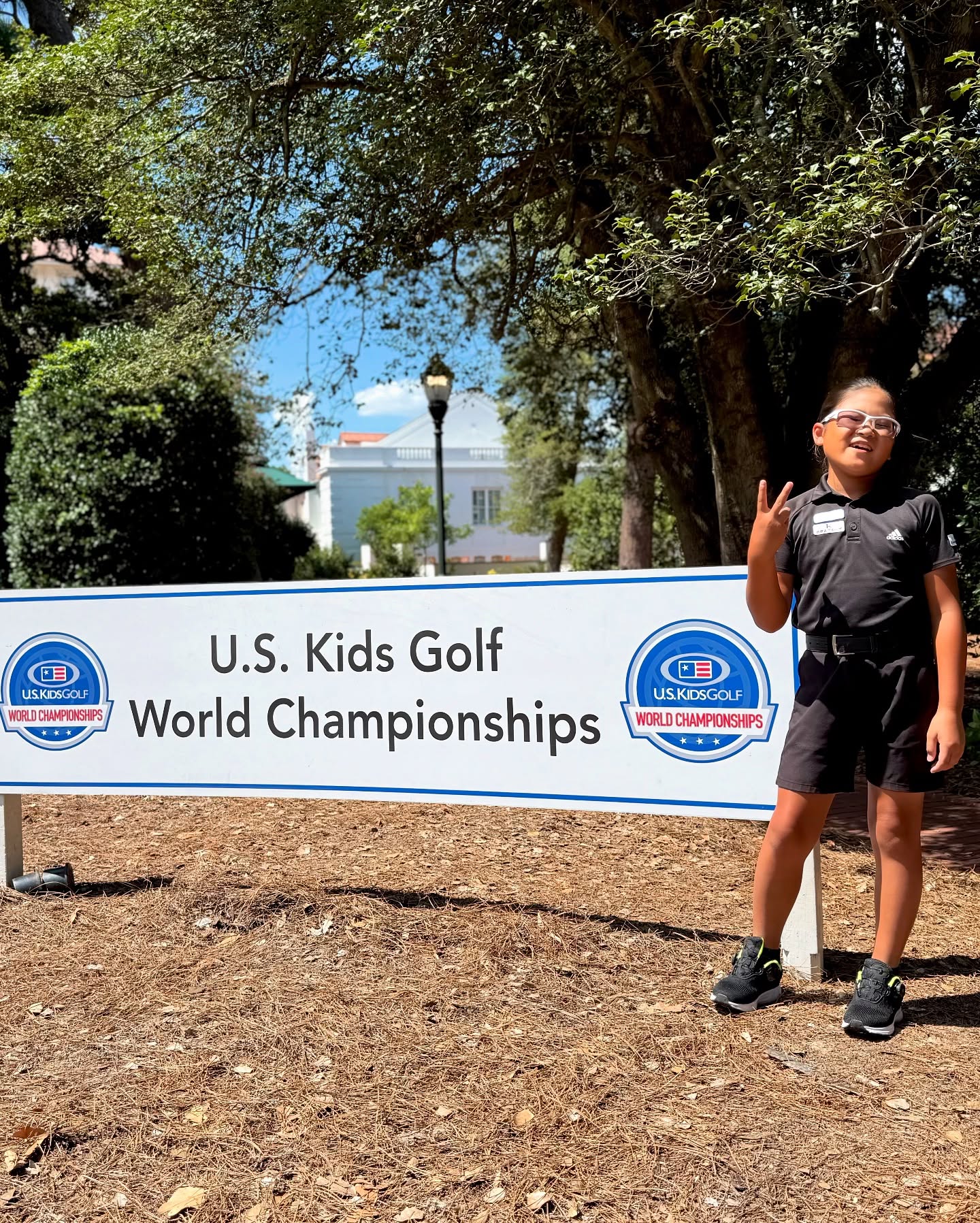 U.S. Kids Golf World Championshipsの看板前に立つ荒砂士道
