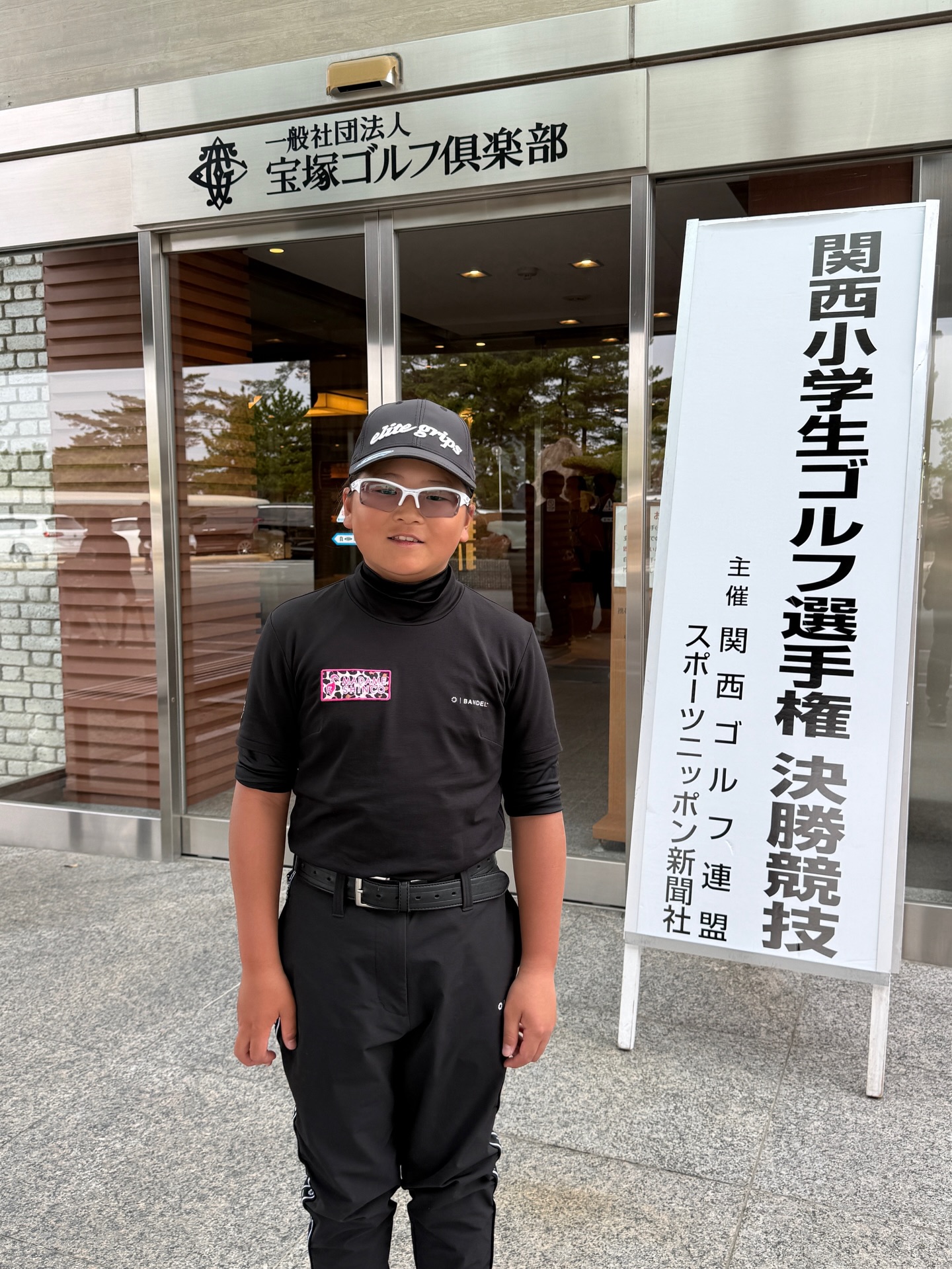 第27回関西小学生ゴルフ選手権決勝競技の看板前に立つ荒砂士道