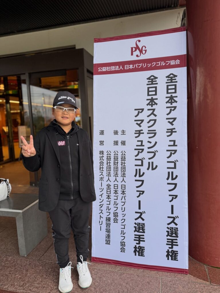 全日本アマチュアゴルファーズ選手権の大会看板前に立つ荒砂士道