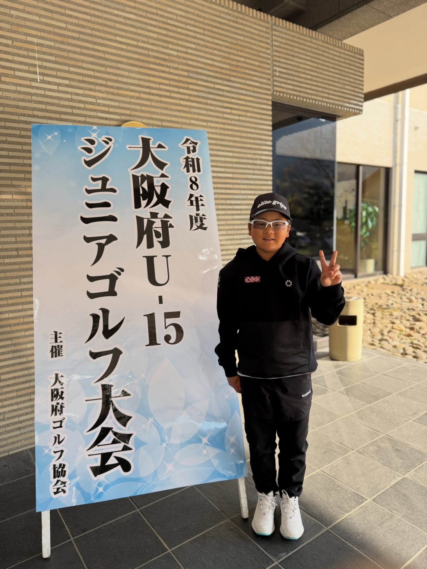 大阪府U-15ジュニアゴルフ大会の看板前に立つ荒砂士道